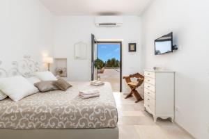 a bedroom with a large bed and a dresser at LA CORTE BIANCA LUXURY VILLA in Ostuni +38 photos