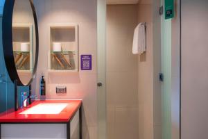 马尼拉ibis Styles Manila Araneta City的带水槽和镜子的浴室