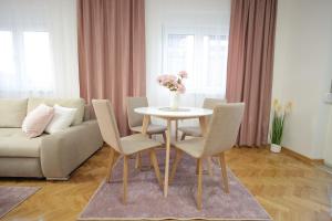 ein Wohnzimmer mit einem Tisch mit Stühlen und einer Couch in der Unterkunft Apartman Babić Lux in Vrnjačka Banja + 31 Fotos