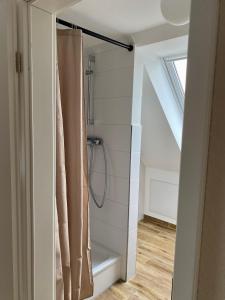 a bathroom with a shower curtain in a room at Ferienhaus Strandleben trifft Kleinstadtleben in Lütjenburg +18 photos