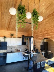 a kitchen with a table and some pendant lights at Komuna in Măguri-Răcătău +30 photos