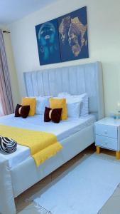 a white bed with pillows on it in a room at Staycation One and Two Bedroom apartment Mombasa in Mombasa +19 photos