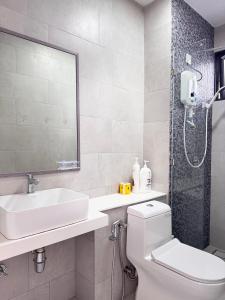 a bathroom with a toilet and a sink and a shower at The Shore by New Voyage in Kota Kinabalu