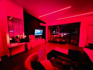 a living room with red lighting and a television at SecretS Room in Baku