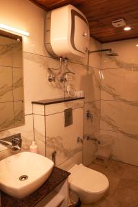a bathroom with a sink and a toilet and a shower at Sansa By The Woods - Manor&Spa in Mussoorie +106 photos
