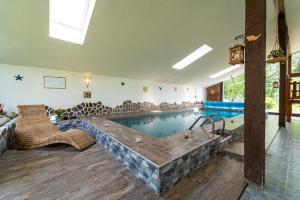 a large swimming pool with a tub in a room at Apartmán Filip wellness,krytý bazén in Tatranska Strba