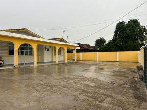 un parking vide devant un bâtiment jaune dans l'établissement Warm Stay No10 Boutique Residence House 7B7B by Verve, à Ipoh