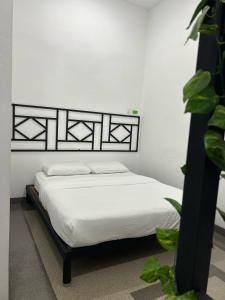 - une chambre avec un lit blanc et une tête de lit noire dans l'établissement Warm Stay No10 Boutique Residence House 7B7B by Verve, à Ipoh