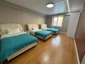two beds in a room with wooden floors at Comfy classic apartment in Central UB in Ulaanbaatar