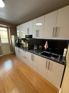 a kitchen with white cabinets and a black counter top at Comfy classic apartment in Central UB in Ulaanbaatar