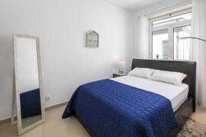 a bedroom with a blue bed and a mirror at Apt. À Porta in Lagos