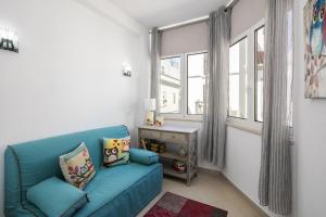 a living room with a blue couch and a window at Apt. À Porta in Lagos