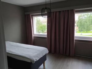 a bedroom with a bed next to a window at Hostel Kulma in Lieksa