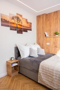 a bedroom with a bed with four paintings on the wall at COCO Old Town in Kielce