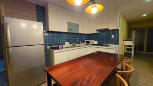 a kitchen with a wooden table and a refrigerator at A-Bridge house 1-A in Incheon