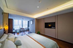 a large bedroom with a large bed and a television at Till Bright Hotel Huaihua High-speed Railway South Station Wanda Plaza in Huaihua