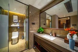 a bathroom with a sink and a toilet and a mirror at Till Bright Hotel Huaihua High-speed Railway South Station Wanda Plaza in Huaihua +45 photos