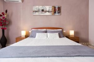 una camera con un letto con due cuscini e due lampade di Seaside Holidays ad Alghero