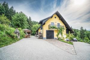 a yellow house with a black roof on a road at Auszeit am Weinhof in Loschenthal