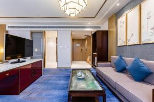 a living room with a couch and a tv at Bliss International Hotel in Weihai