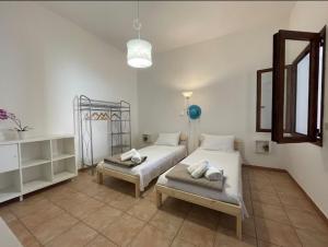 a bedroom with two beds and a mirror at DomuMnG in Elmas