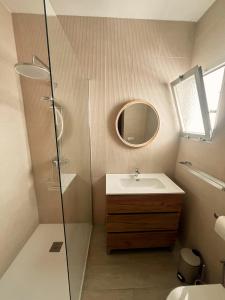 a bathroom with a sink and a glass shower at Casa La Peña - Playa y Naturaleza a un paso in La Redondela