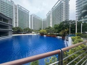 a large swimming pool in a city with tall buildings at The Bahamas & Maldives Suites at Azure Residences near Manila Airport in Manila