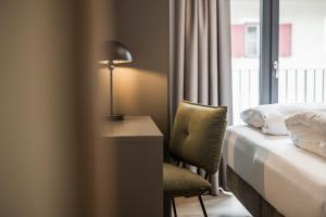 a hotel room with a bed and a desk and a lamp at Gipfelglueck Family in Kirchberg in Tirol