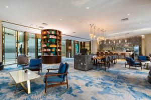 a lobby with chairs and a table and a bar at Bliss International Hotel in Weihai