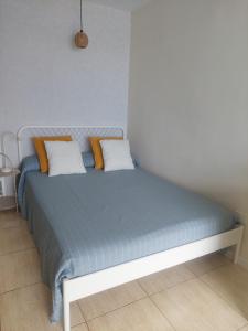 Schlafzimmer mit einem Bett mit blauer Bettwäsche und orangefarbenen Kissen in der Unterkunft Altagay, apartamento con impresionantes vistas al mar y a El Teide in Punta del Hidalgo + 28 Fotos