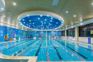 an indoor swimming pool with a swimming lane at Bliss International Hotel in Weihai