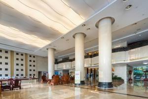 a lobby with columns and tables in a building at Bliss International Hotel in Weihai +31 photos