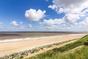 een strand met een rij rotsen en de oceaan bij Lovely 8 Berth Caravan At California Cliffs, Near Scratby Beach Ref 50046L in Great Yarmouth