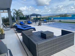 a patio with wicker furniture and a swimming pool at Alto do Moinho in Alcobaça