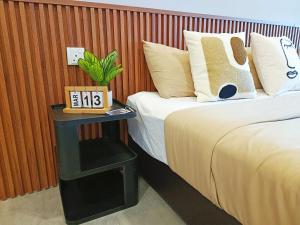 a bedroom with a bed and a table with a clock on it at Imperio Melaka Standard Suites by Jeffery Lam Home Management in Melaka