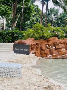 a sign on a beach next to the water at The Bahamas & Maldives Suites at Azure Residences near Manila Airport in Manila