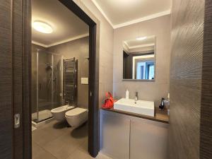 a bathroom with a sink and a toilet and a mirror at Appartamento Flair 43 in Mostacciano  +5 photos