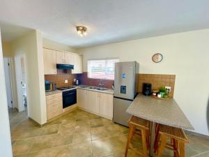 a kitchen with a refrigerator and a table with stools at Central Cozy Apartment at Ane court in Swakopmund +5 photos