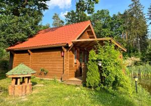 a log cabin with a red roof at Oaza Ławki in Ryn