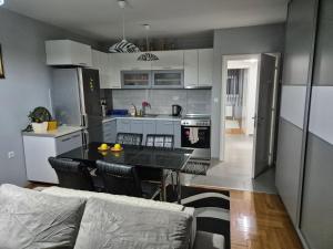 a kitchen and living room with a table and a couch at Eleni Apartment in Bitola