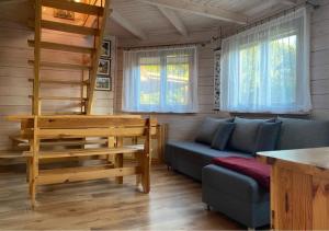 a living room with a blue couch and windows at Oaza Ławki in Ryn
