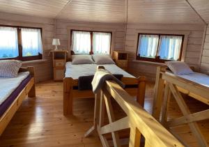 a room with two beds and windows in a cabin at Oaza Ławki in Ryn +82 photos
