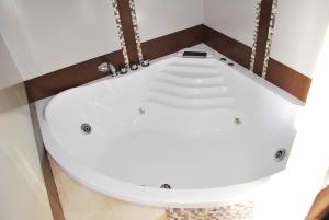 bañera blanca en una habitación con suelo en Hotel De La Barra, en Punta del Este