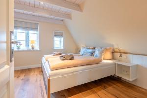 Un dormitorio con una cama en un ático en FriesenLodge, en Utersum