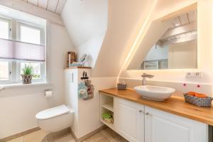 un baño con lavabo e inodoro en FriesenLodge, en Utersum 21 fotos más
