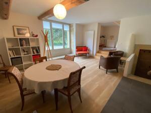 a large living room with a table and chairs at Au Cèdre in Areuse