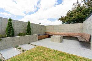 a retaining wall with a bench against a wall at Central Villa Oasis in Whangarei