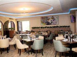 Un restaurante con mesas y sillas en una sala. en Q's Evander Hotel & Apartments, en Evander