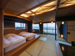 two beds in a room with a view of the ocean at Kaiyutei in Kawazu