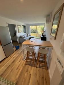 a kitchen and living room with a table and stools at Ocean Lodge Seignosse in Seignosse
